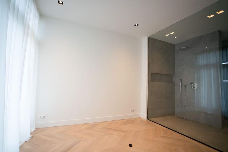 Slaapkamer met douche achter een glazen wand