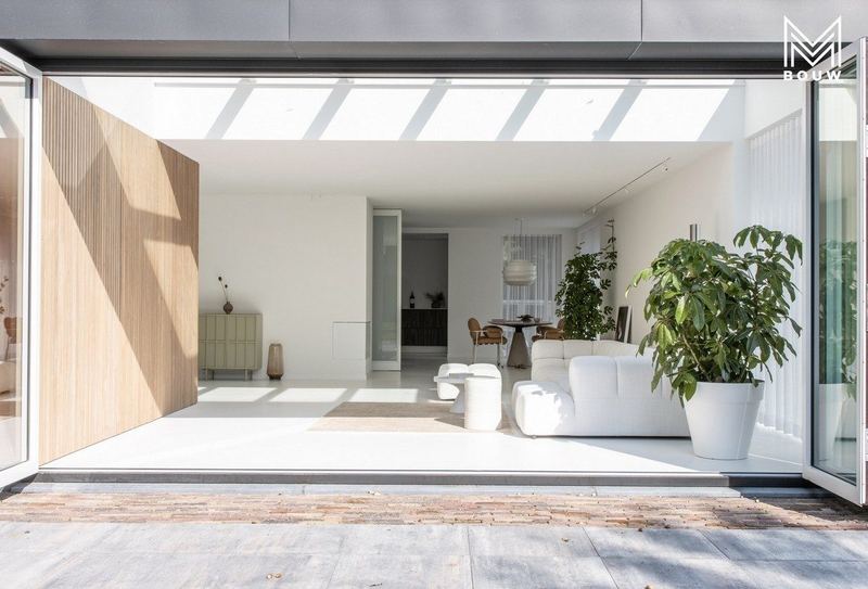 Woonkamer onder de lichtstraat, open naar de tuin