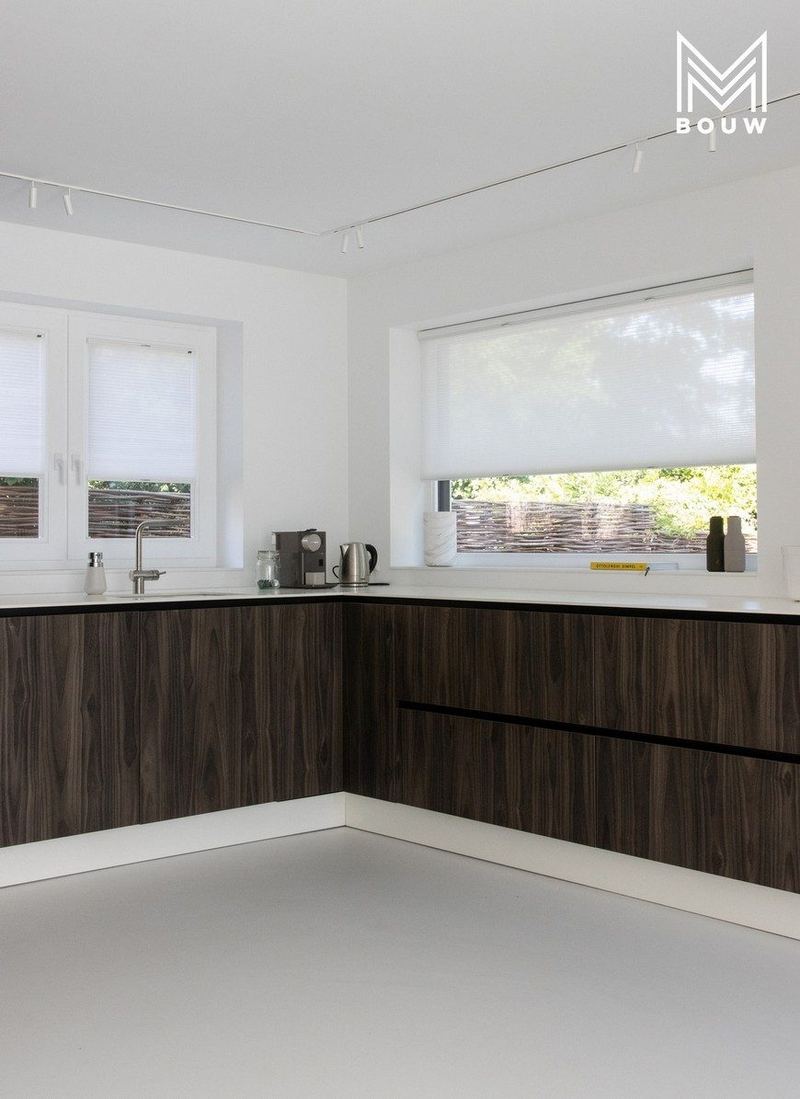 Keuken met donkere houten fronten en wit werkblad