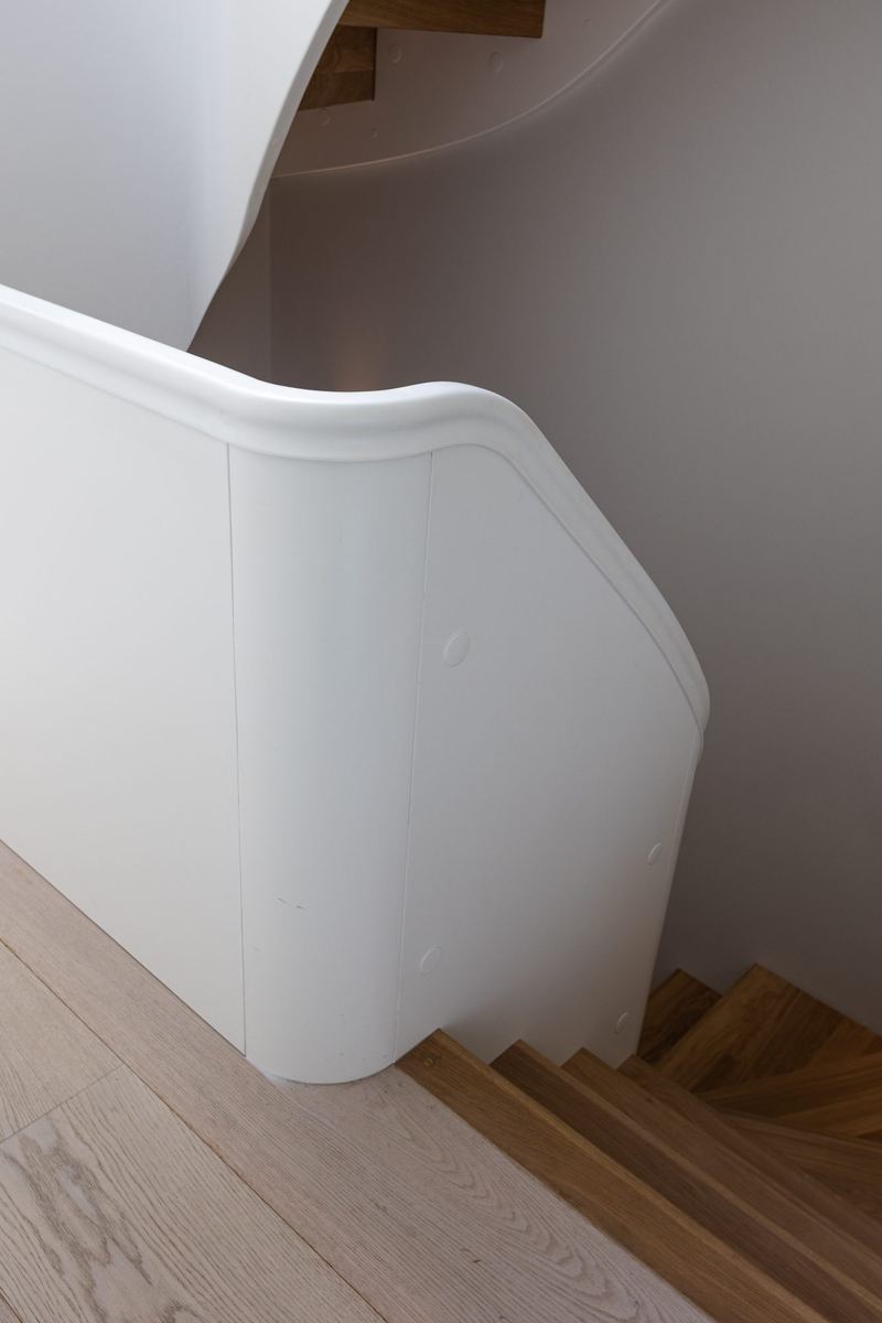 Gebogen trapwand in wit stucwerk
