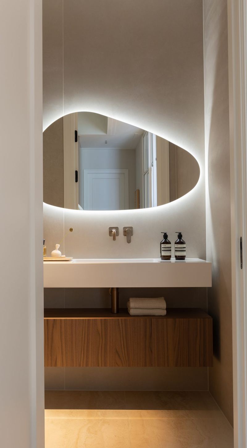 Toilet met verlichte spiegel en notenhouten meubel