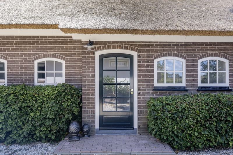 Voordeur met boogramen in het metselwerk
