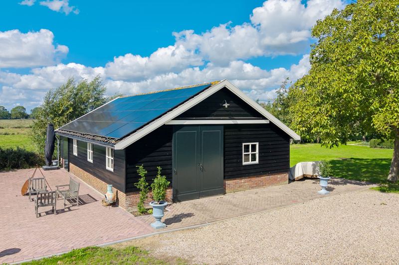 Zwarte houten schuur met tuindeuren